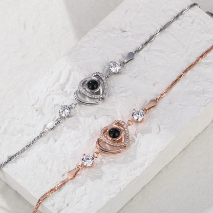 Sterling silver custom double heart projection bracelet with engraved hearts, made by MadeMine, showcasing delicate design and craftsmanship.