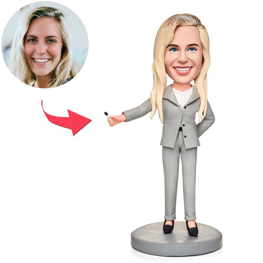 Leerkracht wijst naar schoolbord met gepersonaliseerde bobblehead en gegraveerde tekst, gemaakt door MadeMine.